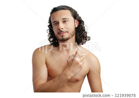 A young man with curly hair applying fragrance after a shower while smiling at the camera A young man with curly hair applying fragrance after a shower while smiling at the camera 121939078