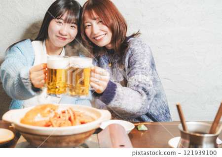 兩位年輕女子在螃蟹火鍋前敬酒[圖片由海鮮居酒屋Uoroko提供] 121939100