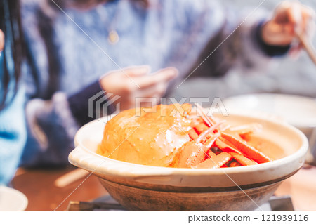 Young women having a girls' night out with crab hotpot [Photo courtesy of Seafood Izakaya Gyoruko] 121939116