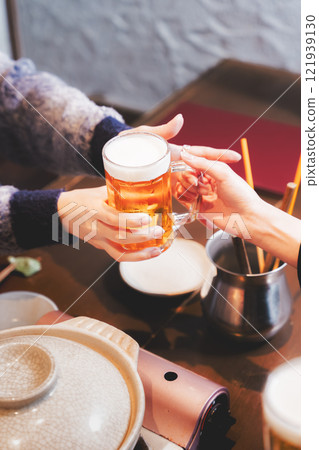 A young woman receiving a beer from a waiter [Photo courtesy of Seafood Izakaya Gyoruko] 121939130