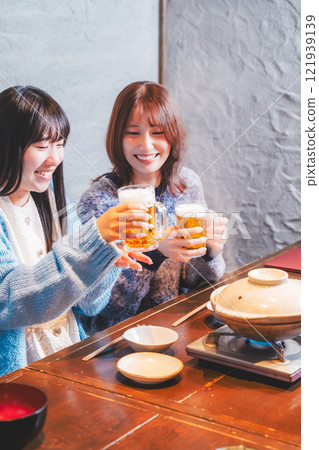 兩位年輕女子在螃蟹火鍋前敬酒[圖片由海鮮居酒屋Uoroko提供] 121939139