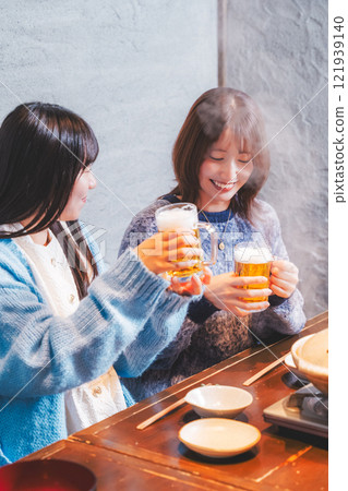 兩位年輕女子在螃蟹火鍋前敬酒[圖片由海鮮居酒屋Uoroko提供] 121939140