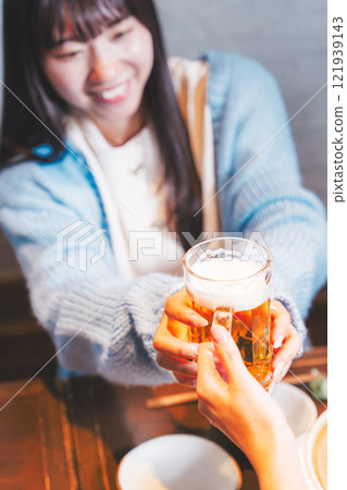 A young woman receiving a beer from a waiter [Photo courtesy of Seafood Izakaya Gyoruko] 121939143