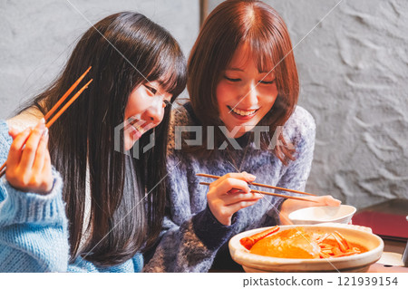 Young women having a girls' night out with crab hotpot [Photo courtesy of Seafood Izakaya Gyoruko] 121939154
