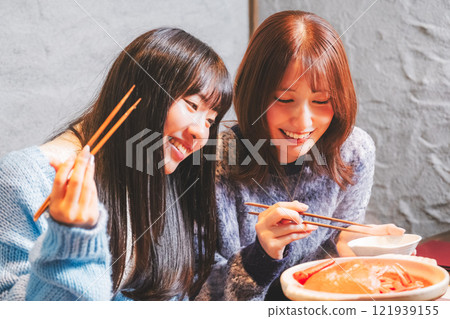 Young women having a girls' night out with crab hotpot [Photo courtesy of Seafood Izakaya Gyoruko] 121939155