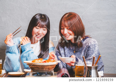 Young women having a girls' night out with crab hotpot [Photo courtesy of Seafood Izakaya Gyoruko] 121939159
