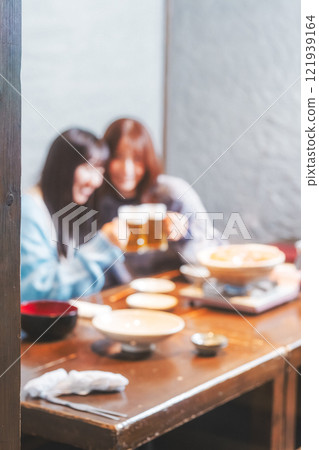 兩位年輕女子在螃蟹火鍋前敬酒[圖片由海鮮居酒屋Uoroko提供] 121939164