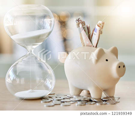 Money, finance and saving with a piggy bank and hourglass on a tablet or desk with time, cash and coins. Financial investment, retirement or planning for the future with a budget and growth strategy Money, finance and saving with a piggy bank and hourglass on a tablet or desk with time, cash and coins. Financial investment, retirement or planning for the future with a budget and growth strategy 121939349
