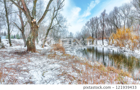 Outstanding landscape in city park with snowy trees and beautiful frozen river. 121939433