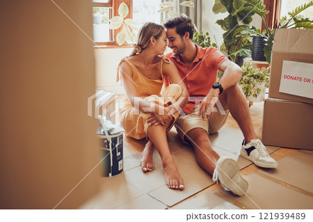 Romance, fun and an intimate moment between a couple moving into a new home. Young lovers being affectionate, flirting and enjoying a conversation. Husband and wife taking a break from unpacking 121939489