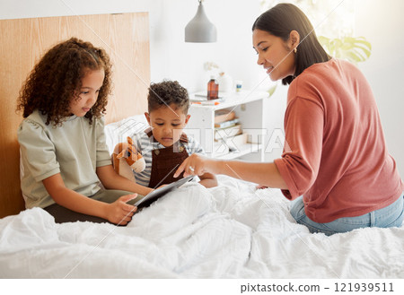 Mother and children browsing a digital tablet in the bed at home, bonding and learning to use technology. Family on the internet online to play games and learn from educational apps or website Mother and children browsing a digital tablet in the bed at home, bonding and learning to use technology. Family on the internet online to play games and learn from educational apps or website 121939511
