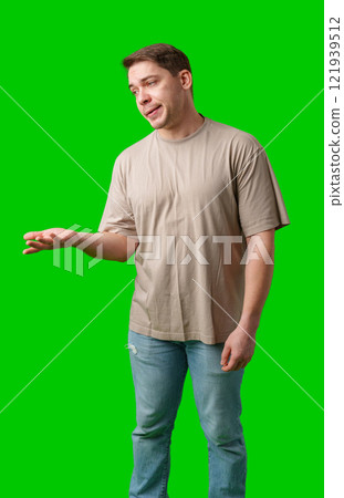 Man with a confused expression gestures with his hands against a bright green background 121939512