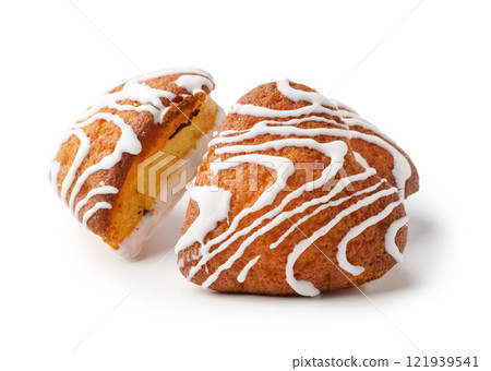 Sweet treats on a white background with icing drizzled on top and a cut view revealing the soft, moist interior 121939541