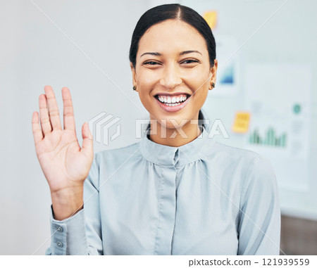 Woman waving hand to greet hello while introducing, smiling and gesturing during video call via webcam in virtual meeting in an office. Portrait of a young, friendly and happy female business intern Woman waving hand to greet hello while introducing, smiling and gesturing during video call via webcam in virtual meeting in an office. Portrait of a young, friendly and happy female business intern 121939559