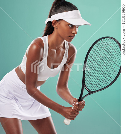 Tennis player, professional and sporty woman holding a racket looking serious and ready to play in a competition. Healthy, fit and athletic female in sports ball game pose over studio background. 121939600