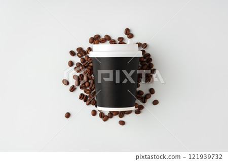 A paper coffee cup surrounded by freshly roasted coffee beans on a clean white background A paper coffee cup surrounded by freshly roasted coffee beans on a clean white background 121939732