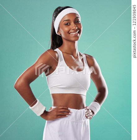 Happy, confident and smiling tennis player in sports uniform and hands on hips while ready to play with positive attitude. Fit and sporty female standing against a studio background with copy space Happy, confident and smiling tennis player in sports uniform and hands on hips while ready to play with positive attitude. Fit and sporty female standing against a studio background with copy space 121939845