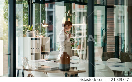 A modern office, building interior and a businesswoman doing online research on a tablet or looking at files. Female inside her corporate workplace architecture indoors preparing for a presentation. A modern office, building interior and a businesswoman doing online research on a tablet or looking at files. Female inside her corporate workplace architecture indoors preparing for a presentation. 121939857