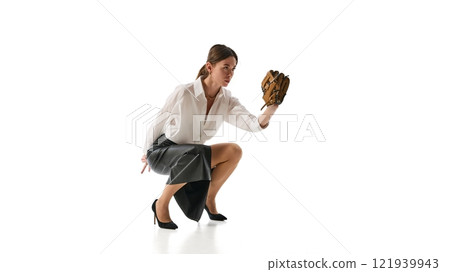 Woman crouched holding baseball glove, embodying strategic preparation and concentration in decision-making against white studio background. 121939943