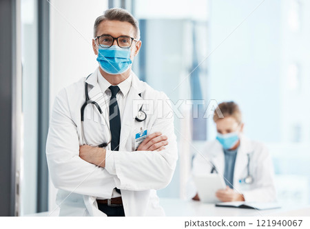 Doctor, physician or healthcare professional with covid face mask in a hospital for medical health insurance background. Innovation, leadership and excellence male gp portrait with his arms crossed Doctor, physician or healthcare professional with covid face mask in a hospital for medical health insurance background. Innovation, leadership and excellence male gp portrait with his arms crossed 121940067