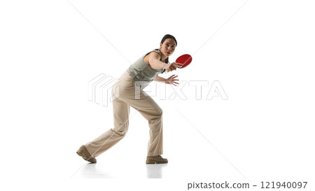Woman dressed formalwear holding red ping-pong paddle ready to play, portraying confidence and balance against white studio background. 121940097