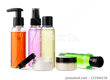 Variety of colorful personal care bottles and grooming accessories arranged on a white surface Variety of colorful personal care bottles and grooming accessories arranged on a white surface 121940136