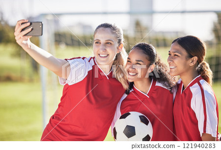 Selfie, soccer and sports team smiling and feeling happy while posing for a social media picture. Diverse and young girls standing together on a football field. Friends and teammates enjoying a match Selfie, soccer and sports team smiling and feeling happy while posing for a social media picture. Diverse and young girls standing together on a football field. Friends and teammates enjoying a match 121940283