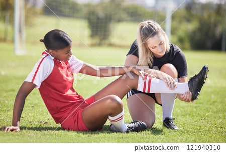 Soccer, sports and injury of a female player suffering with sore leg, foot or ankle on the field. Painful, hurt and discomfort woman getting her pain checked out by athletic trainer on the pitch. Soccer, sports and injury of a female player suffering with sore leg, foot or ankle on the field. Painful, hurt and discomfort woman getting her pain checked out by athletic trainer on the pitch. 121940310