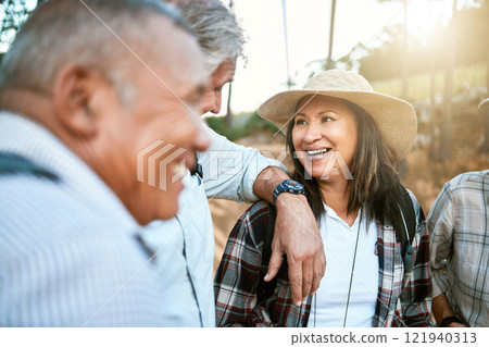 Happy senior woman in nature with friends while taking an outdoor walk in spring. Smiling mature woman having a conversation with a man outside. Old smiling lady having fun while hiking with aged men Happy senior woman in nature with friends while taking an outdoor walk in spring. Smiling mature woman having a conversation with a man outside. Old smiling lady having fun while hiking with aged men 121940313