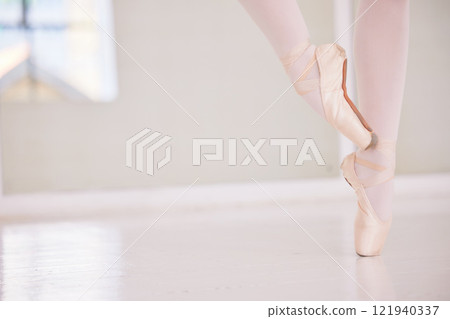 Ballet feet or legs on the tiptoe dancing or practicing in a dance studio or class with copy space. Closeup of an elegant dancer or ballerina in pointe shoes preparing for a performance Ballet feet or legs on the tiptoe dancing or practicing in a dance studio or class with copy space. Closeup of an elegant dancer or ballerina in pointe shoes preparing for a performance 121940337