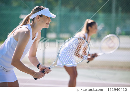 Fun women playing tennis match, practicing for competition and getting ready for sporty fitness game on a court outside, Female friends and teammates doing cardio training and sports workout together 121940410