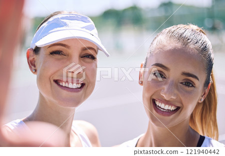 Selfie of smiling, tennis and active women looking happy after a successful sporty match outdoor in the summer sunlight. Excited friends with big smile on face enjoying a friendly day on the court Selfie of smiling, tennis and active women looking happy after a successful sporty match outdoor in the summer sunlight. Excited friends with big smile on face enjoying a friendly day on the court 121940442