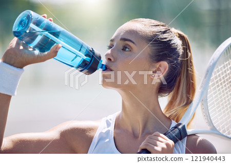 Health, fitness and water, a woman tennis player on a break, drinking from a plastic bottle during a match on the court. Beautiful young lady playing sports, training for a healthy summer lifestyle. Health, fitness and water, a woman tennis player on a break, drinking from a plastic bottle during a match on the court. Beautiful young lady playing sports, training for a healthy summer lifestyle. 121940443
