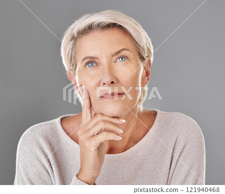 Mature, thinking and woman touching her face in isolated grey studio background. Copy space for anti ageing skincare or cosmetic products for senior feeling her skin and wrinkles headshot. 121940468