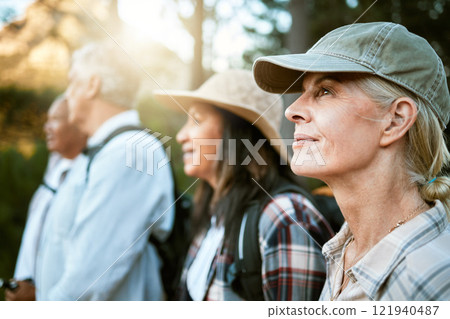Hiking, adventure and exploring with a group of senior friends enjoying a walk or nature hike in the forest or woods outdoors. Closeup of mature retired people on a journey for outside discovery. Hiking, adventure and exploring with a group of senior friends enjoying a walk or nature hike in the forest or woods outdoors. Closeup of mature retired people on a journey for outside discovery. 121940487