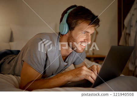 Laptop, video and man streaming a movie in his bedroom on tv via internet while relaxed, smile and enjoying content. Headphones, house and happy male watching series on computer pc at night at home Laptop, video and man streaming a movie in his bedroom on tv via internet while relaxed, smile and enjoying content. Headphones, house and happy male watching series on computer pc at night at home 121940508
