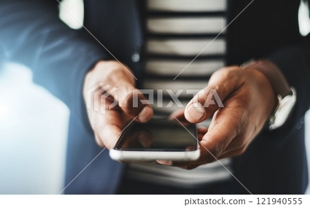Hands of business man typing on phone, networking on social media and browsing internet at work. Closeup of a professional corporate employee checking a text, scrolling an app and reading message 121940555