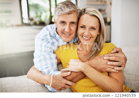 Happy, in love and affectionate senior couple hugging on the sofa in the living at room, enjoying time together and their retirement. Portrait of a happy man and woman bonding and smiling at home Happy, in love and affectionate senior couple hugging on the sofa in the living at room, enjoying time together and their retirement. Portrait of a happy man and woman bonding and smiling at home 121940559