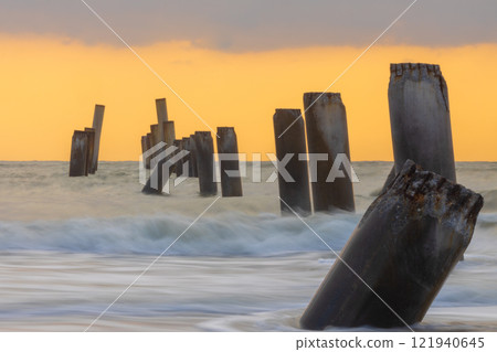 A beautiful sunrise at Sao Eang Beach (old leaning cement pillars) Cha-Am beach, Phetchaburi, Thailand. 121940645