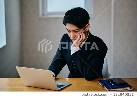A young man in his 20s thinking 121940831