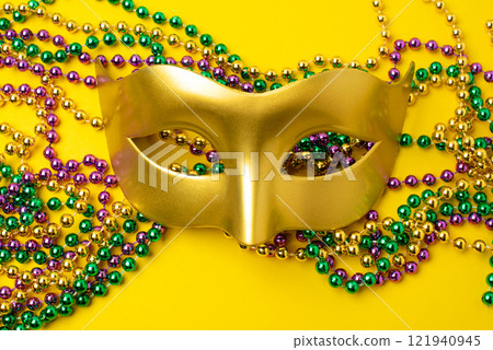Mardi Gras beads on yellow background 121940945