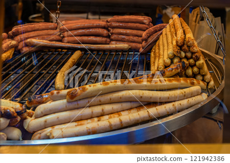 Grilled sausages on a barbecue at food market. Concept of street food Grilled sausages on a barbecue at food market. Concept of street food 121942386