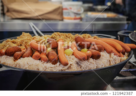Traditional German sausages and sauerkraut on market stall. Concept of festive food and street cuisine Traditional German sausages and sauerkraut on market stall. Concept of festive food and street cuisine 121942387