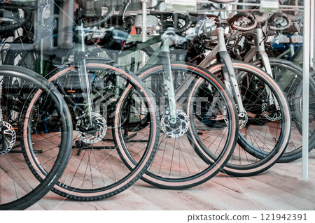 Bicycles displayed in a shop window with reflections. Concept of modern transportation, eco-friendly lifestyle Bicycles displayed in a shop window with reflections. Concept of modern transportation, eco-friendly lifestyle 121942391