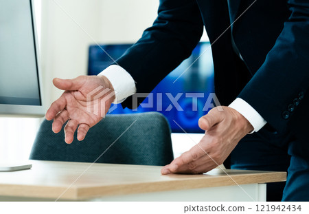 A businessman explaining in front of a computer 121942434