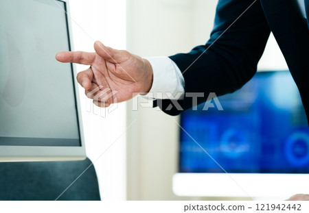 A businessman explaining in front of a computer A businessman explaining in front of a computer 121942442