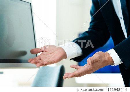 A businessman explaining in front of a computer 121942444