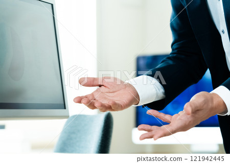 A businessman explaining in front of a computer 121942445