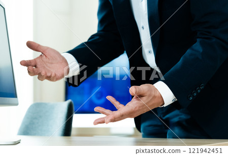 A businessman explaining in front of a computer 121942451