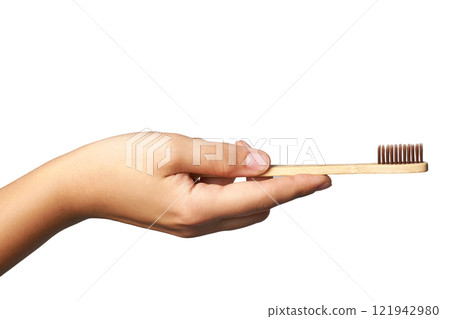 Hand holding eco friendly bamboo toothbrush for sustainable oral care 121942980